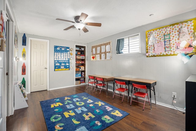 interior space featuring ceiling fan, baseboards, and wood finished floors