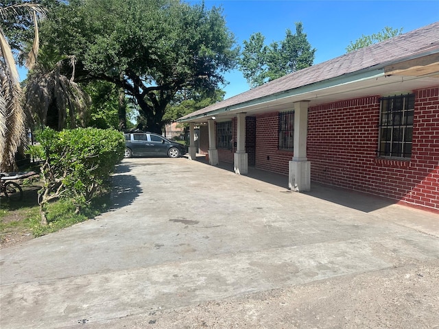 view of home's exterior featuring concrete driveway and brick siding