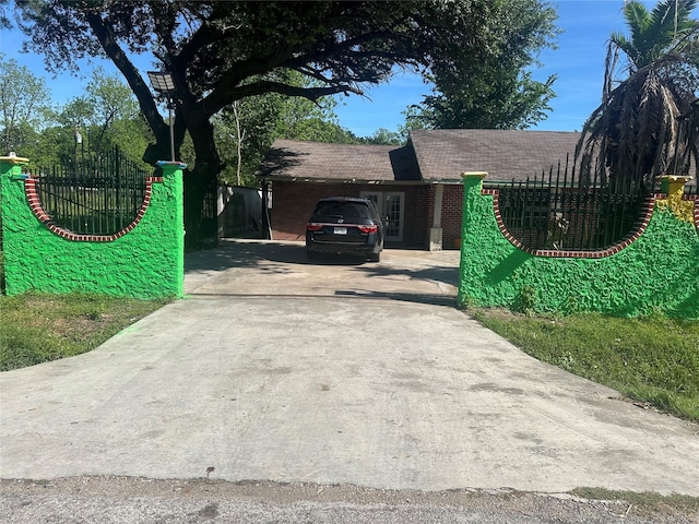 exterior space with roof with shingles, fence, and driveway