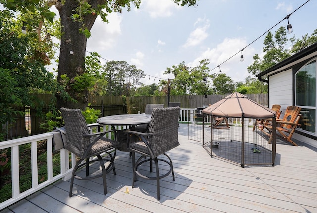 deck featuring outdoor dining area and a fenced backyard