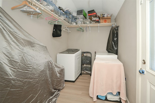 washroom with light wood-type flooring, laundry area, and washing machine and clothes dryer