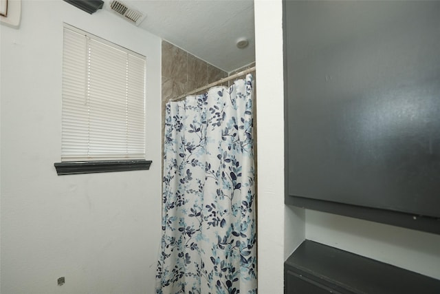 bathroom featuring curtained shower and visible vents