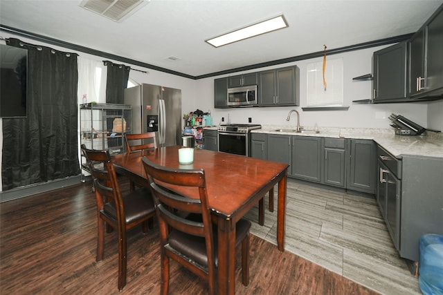 kitchen featuring visible vents, wood finished floors, light countertops, stainless steel appliances, and a sink