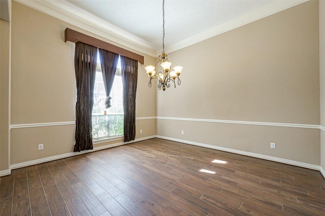 spare room featuring a notable chandelier, baseboards, wood finished floors, and crown molding