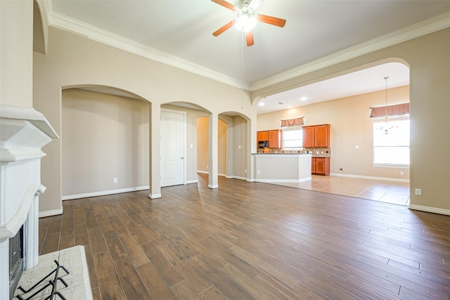 unfurnished living room with plenty of natural light, ceiling fan, and wood finished floors