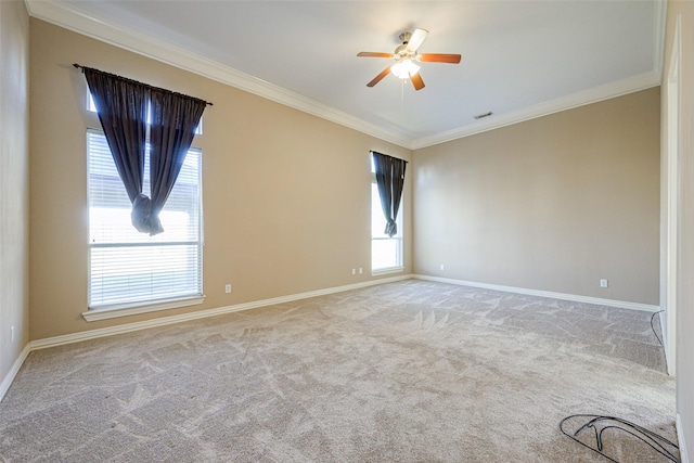 spare room with visible vents, baseboards, a ceiling fan, ornamental molding, and carpet flooring