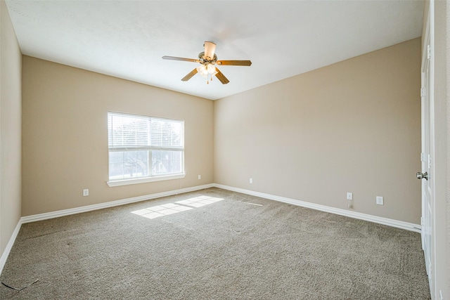 carpeted spare room with ceiling fan and baseboards