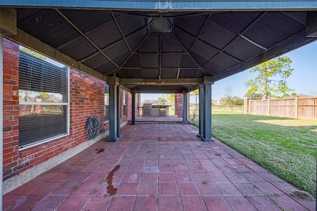 view of patio with fence, exterior kitchen, and a gazebo