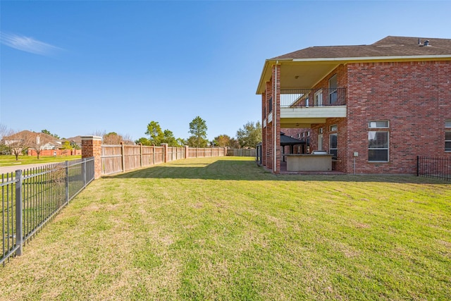 view of yard with a balcony and a fenced backyard