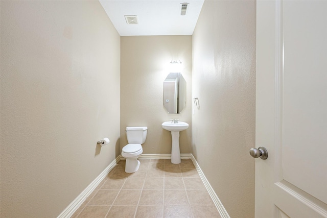 half bathroom featuring tile patterned flooring, baseboards, visible vents, and toilet