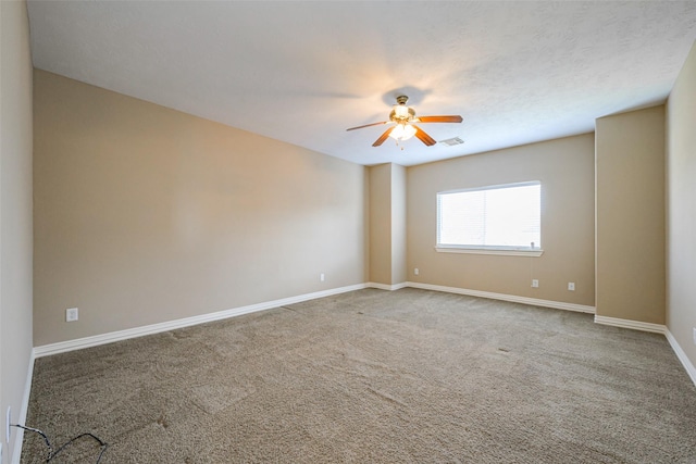 spare room with carpet floors, visible vents, ceiling fan, a textured ceiling, and baseboards