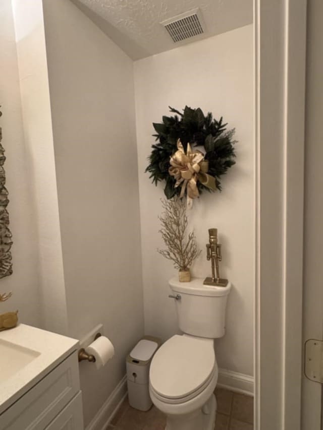 bathroom with visible vents, toilet, tile patterned floors, a textured ceiling, and vanity