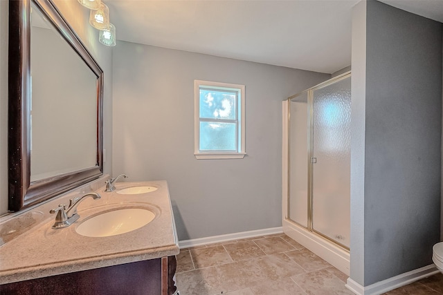 full bathroom featuring a stall shower, toilet, a sink, and baseboards