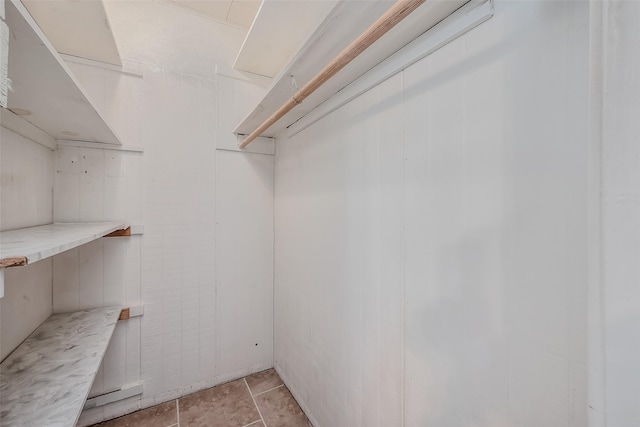 walk in closet with light tile patterned floors