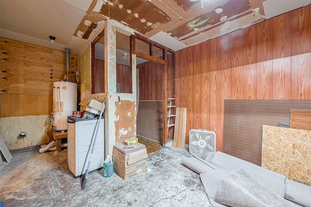 miscellaneous room with gas water heater and unfinished concrete flooring