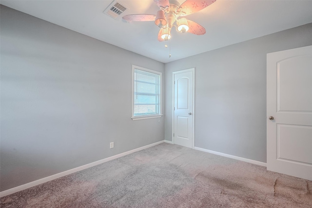 spare room featuring carpet, visible vents, ceiling fan, and baseboards