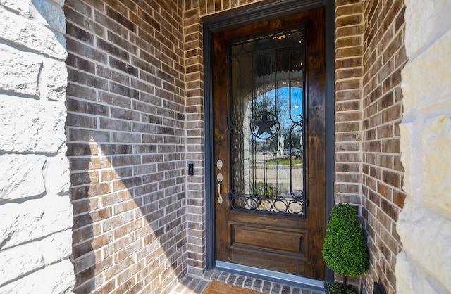 view of exterior entry featuring brick siding