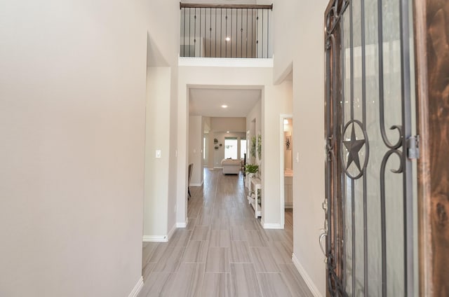 foyer featuring wood finished floors, a towering ceiling, and baseboards