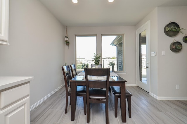 dining space featuring light wood finished floors, baseboards, and recessed lighting