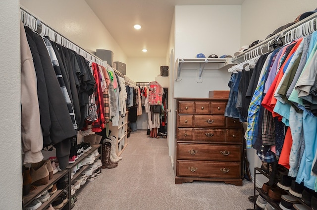 walk in closet with light carpet