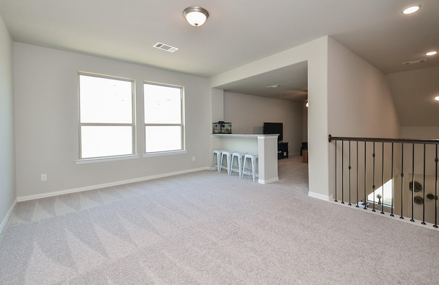 empty room featuring carpet floors, recessed lighting, visible vents, and baseboards