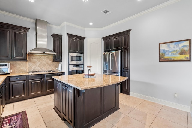 kitchen with light tile patterned flooring, a center island, appliances with stainless steel finishes, light stone countertops, and wall chimney exhaust hood