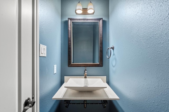 bathroom with a sink and a textured wall