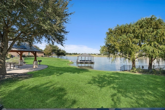 view of dock featuring a water view, a yard, a gazebo, and fence