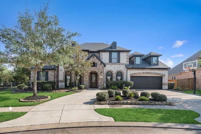 french provincial home featuring a garage, brick siding, fence, driveway, and stone siding