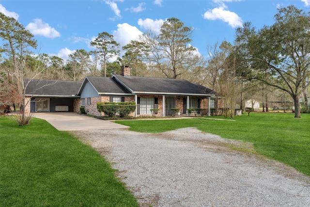 ranch-style home featuring gravel driveway, brick siding, a chimney, and a front lawn