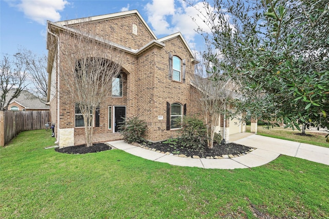 traditional home with a front yard, brick siding, driveway, and fence