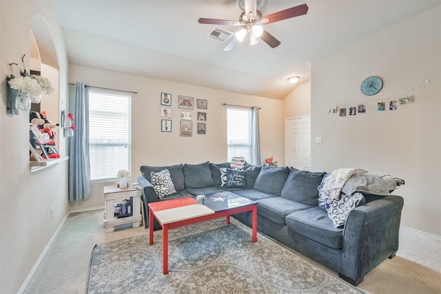 living area with a wealth of natural light, carpet flooring, vaulted ceiling, and visible vents