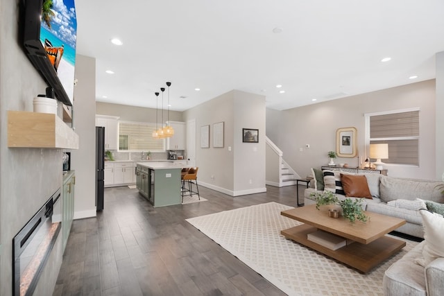 living room with dark wood-style floors, stairway, baseboards, and recessed lighting