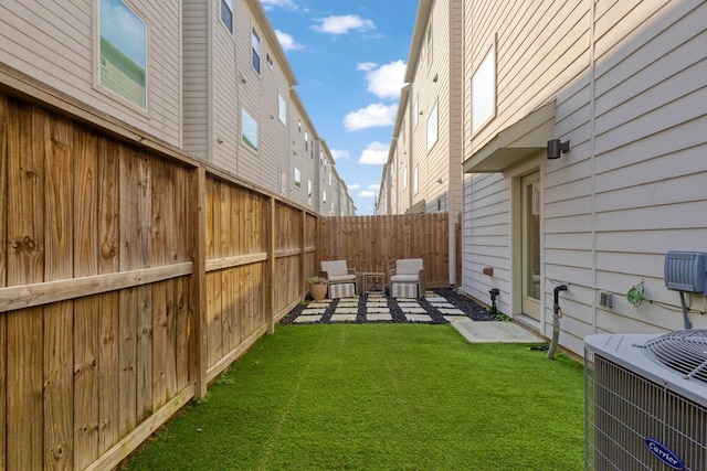 view of yard featuring central air condition unit, fence private yard, and a patio area