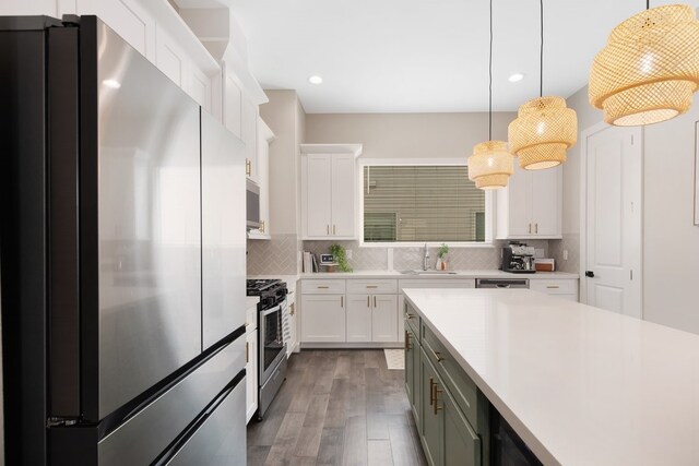 kitchen with light countertops, appliances with stainless steel finishes, backsplash, and white cabinetry