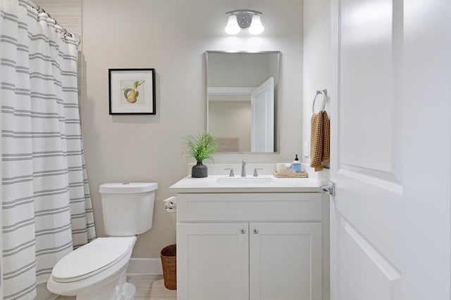 bathroom featuring baseboards, vanity, toilet, and a shower with curtain