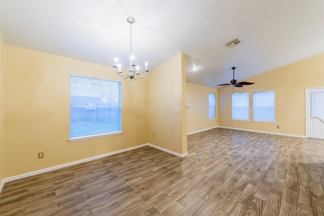 unfurnished room with lofted ceiling, visible vents, plenty of natural light, and wood finished floors