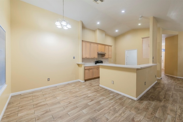 kitchen with light wood finished floors, light countertops, light brown cabinetry, a chandelier, and under cabinet range hood