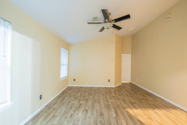 empty room featuring light wood-style floors, visible vents, baseboards, and a ceiling fan