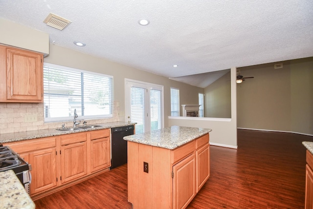 kitchen featuring dishwasher, a kitchen island, dark wood-type flooring, a fireplace, and a sink