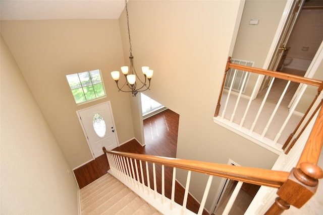 entryway with a high ceiling, stairway, and a notable chandelier