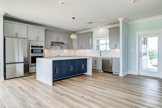 kitchen with gray cabinets, stainless steel appliances, crown molding, light countertops, and under cabinet range hood