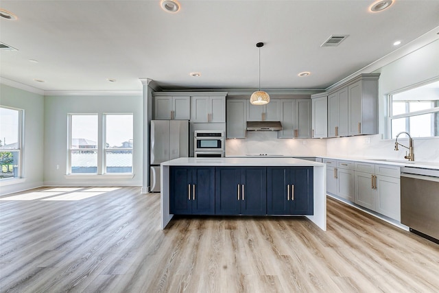 kitchen featuring under cabinet range hood, a sink, visible vents, appliances with stainless steel finishes, and gray cabinets