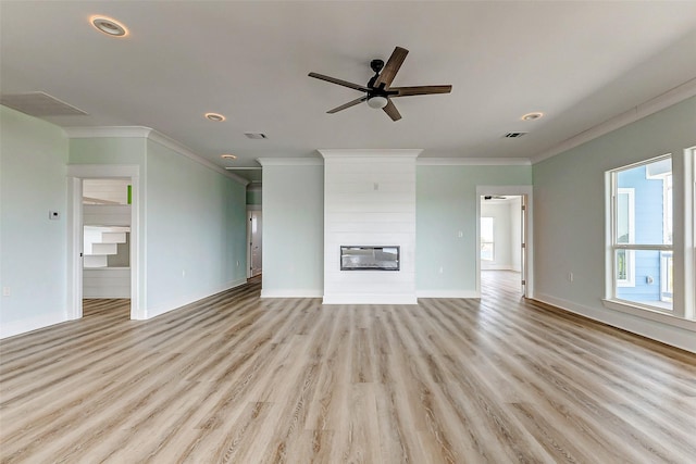 unfurnished living room featuring a large fireplace, light wood-style flooring, and crown molding