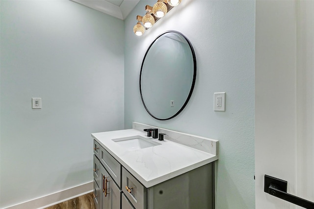 bathroom featuring vanity, baseboards, and wood finished floors