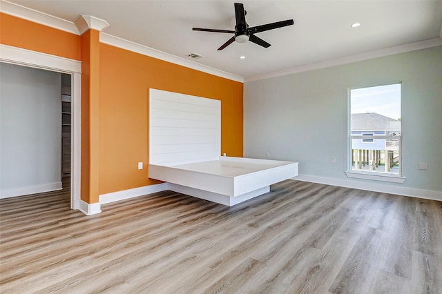 interior space with ornamental molding, visible vents, baseboards, and wood finished floors