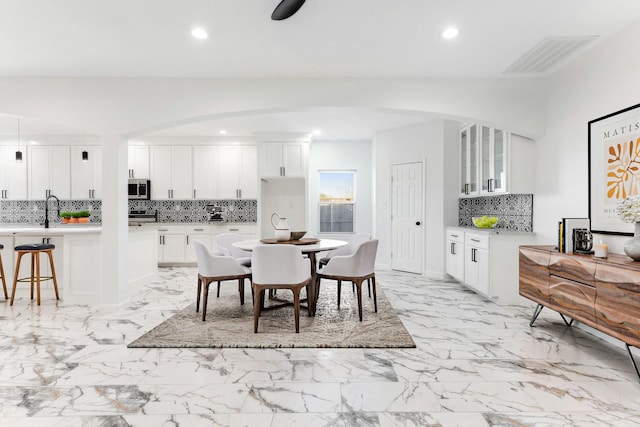 dining space with recessed lighting, visible vents, marble finish floor, and arched walkways