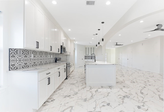 kitchen featuring a sink, ceiling fan, white cabinets, appliances with stainless steel finishes, and marble finish floor