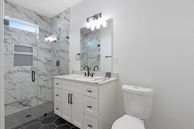 bathroom featuring a marble finish shower, toilet, and vanity