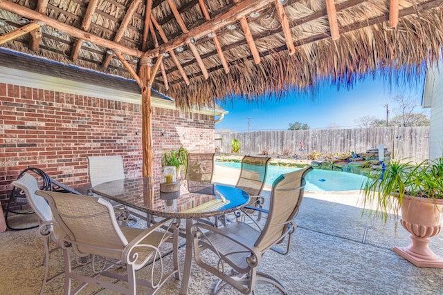 view of patio featuring a gazebo, outdoor dining area, fence private yard, and a fenced in pool